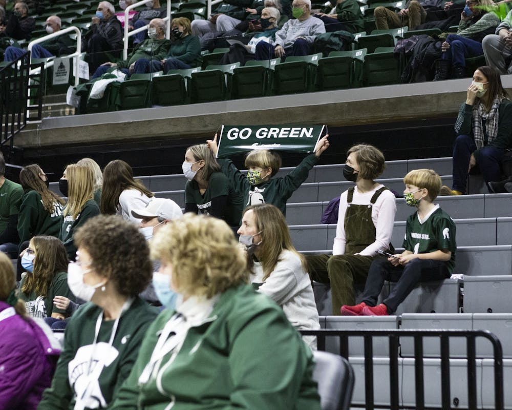 <p>A child in the stands holds up a Go Green banner at the Michigan State University versus Minnesota women’s basketball game on Jan. 23, 2022.</p>