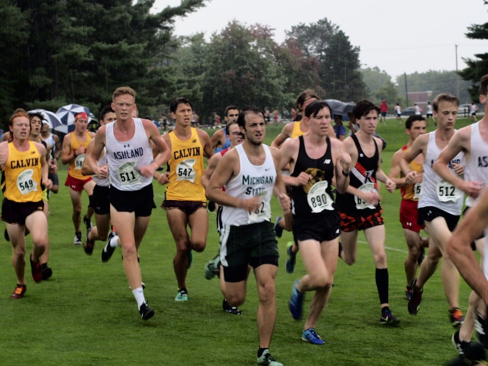 College men's cross country runners run through heavy rains during the Spartan Invitational cross country meet at Forest Akers Golf Course on September 13, 2019. 