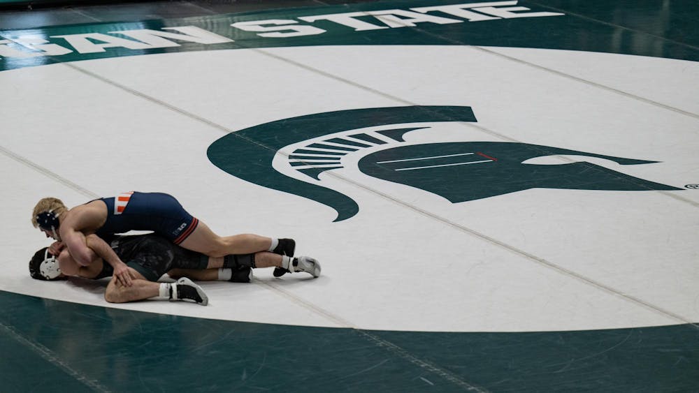 <p>An Illinois wrestler works from the top position against a Michigan State opponent during their dual at Jenison Field House in East Lansing on Friday, Jan. 16, 2026.</p>