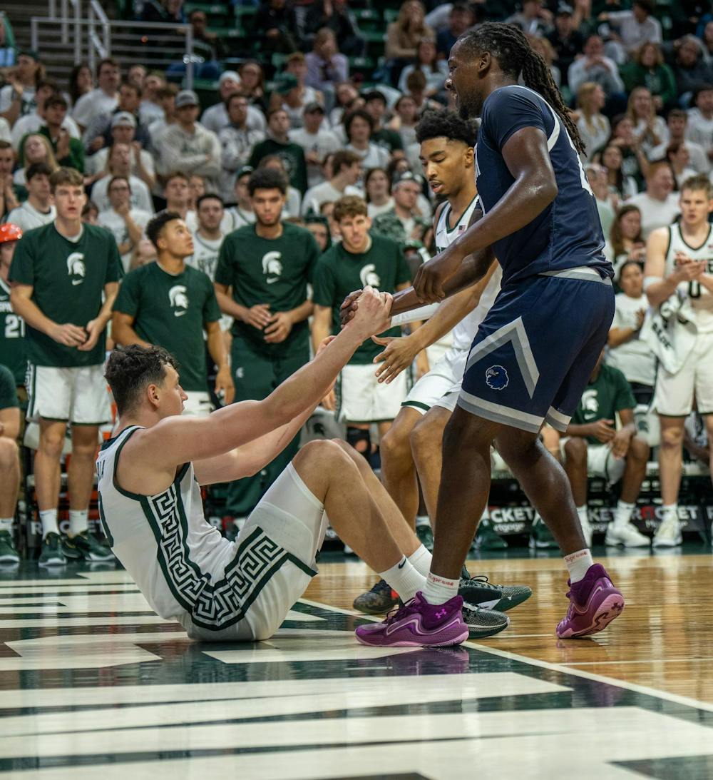 <p>MSU senior guard Jaden Akins (3), along with a player from the opposing team, helps senior center Szymon Zapala (10) during their game against Monmouth University at the Breslin Center on Nov. 4, 2024.</p>