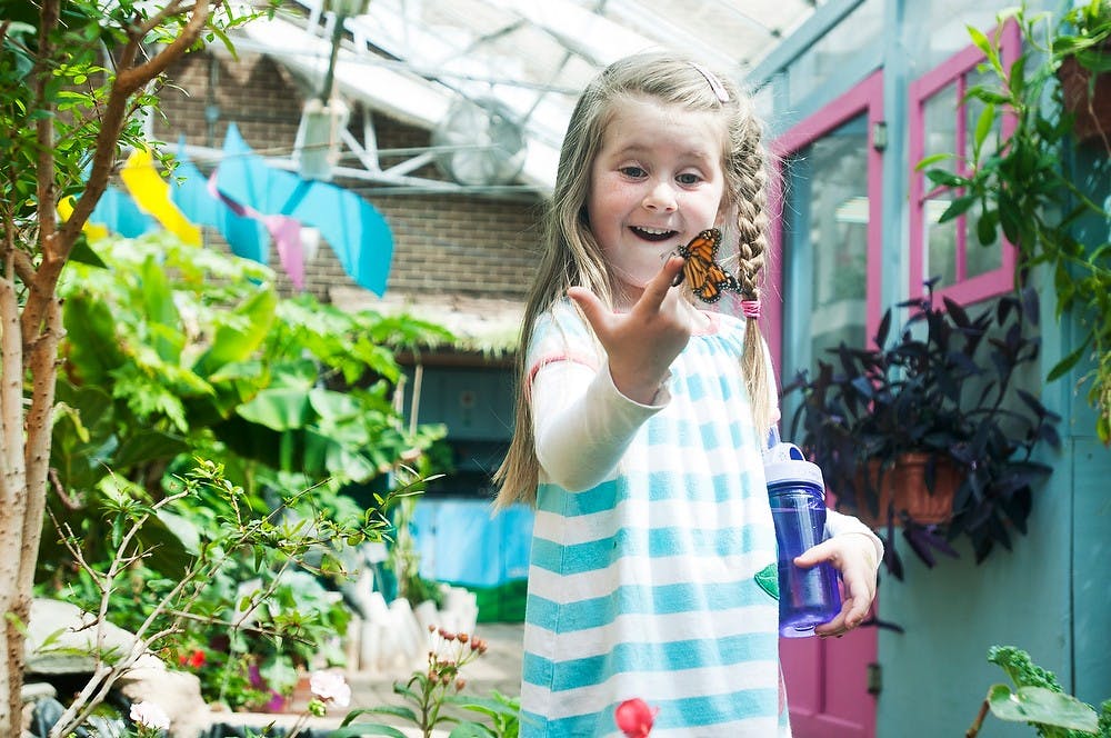 <p>Okemos, Mich., resident Hannah Meoak, 4, catches a butterfly on her finger April 21, 2014, at the Indoor Children's Garden and Butterfly House near Plant and Soil Sciences. Meoak, along with friends and family, was there for the first time. Danyelle Morrow/The State News</p>