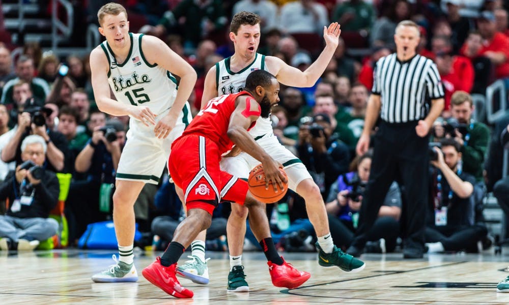 <p>Junior guard Foster Loyer (right) draws an offensive foul from Ohio State&#x27;s Keyshawn Woods. The Spartans beat the Buckeyes, 77-70 at the United Center on March 15, 2019.</p>