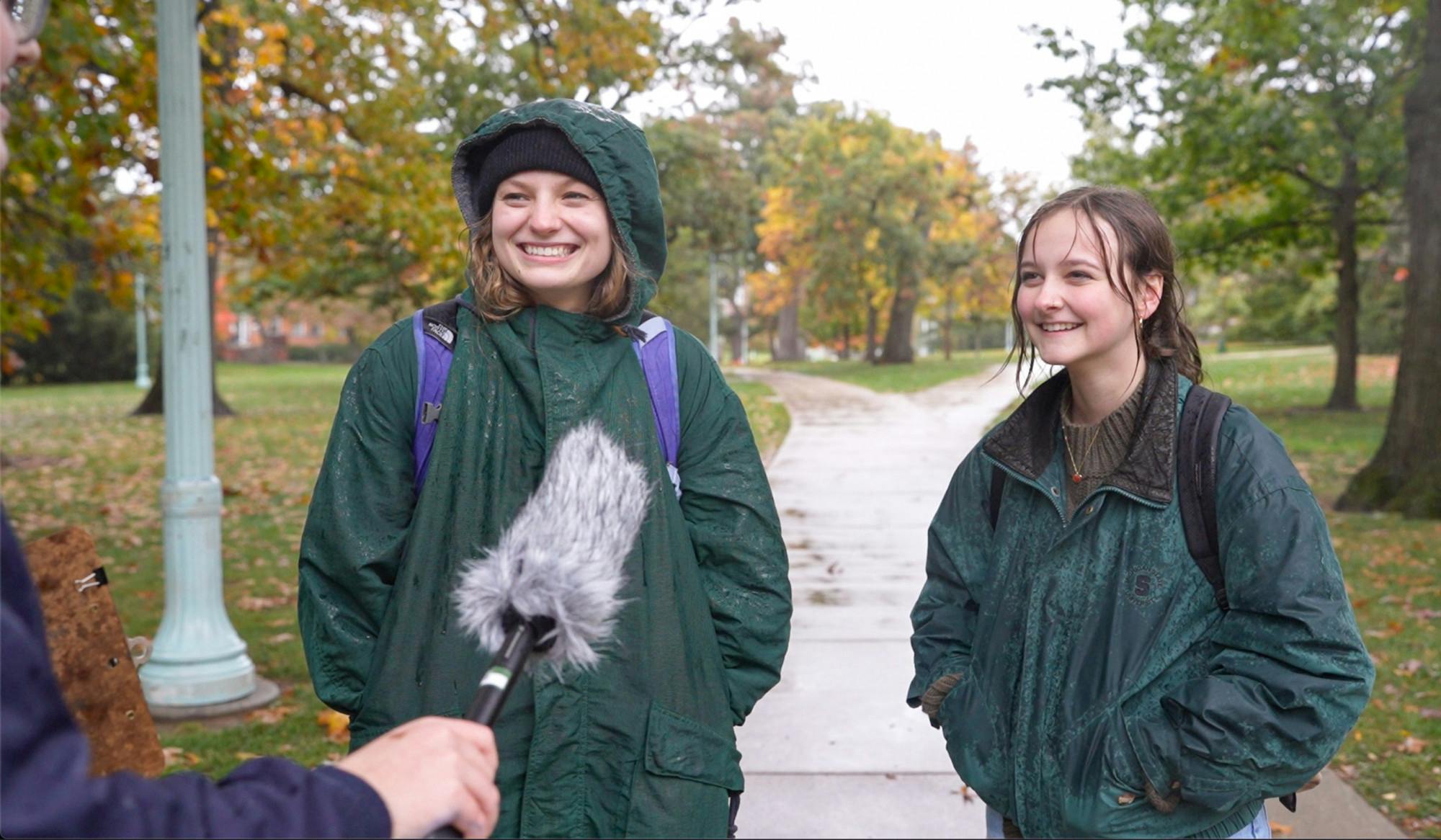 Third-year experience architecture students Megan Gleason (left) and Cameryn Hatfield (right) answer questions about a alcohol use study on college campuses including Michigan State, University of Michigan, Ohio State and Western Michigan University on Oct. 18, 2022. 