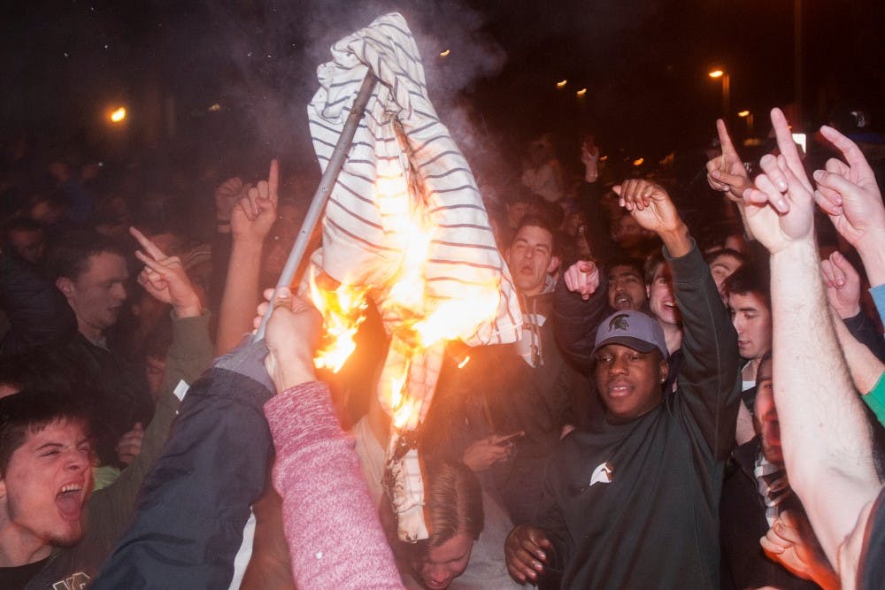 <p>A shirt is burned during a riot in the streets of Cedar Village on Dec. 8, 2013. The police and fire department responded to multiple riots and fires across East Lansing.</p>