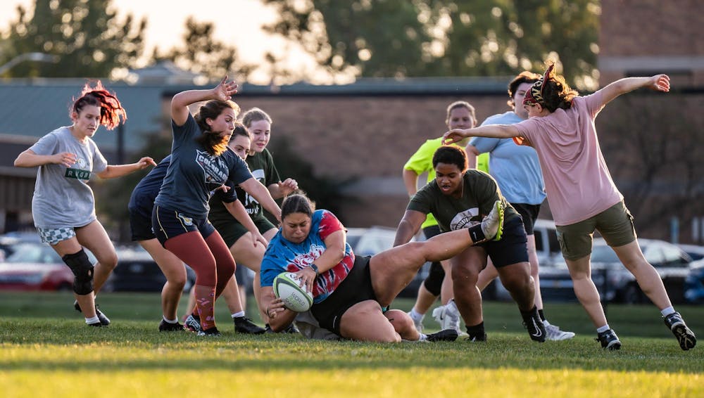 <p>Michigan State University rugby football club president Isabel Perez gets tackled to the ground during practice at the Vet Med Field on Sept. 16, 2024. The team was preparing for their match against Purdue University on Sept. 21, 2024.</p>