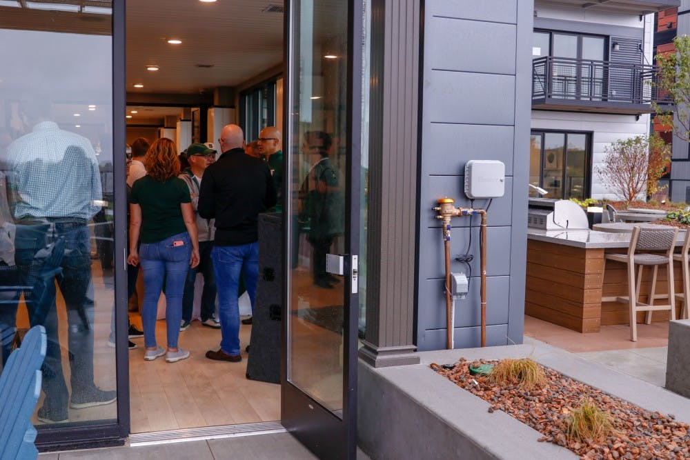 Attendees talk indoors at Newman Lofts’ Grand Opening Sep. 28, 2019.