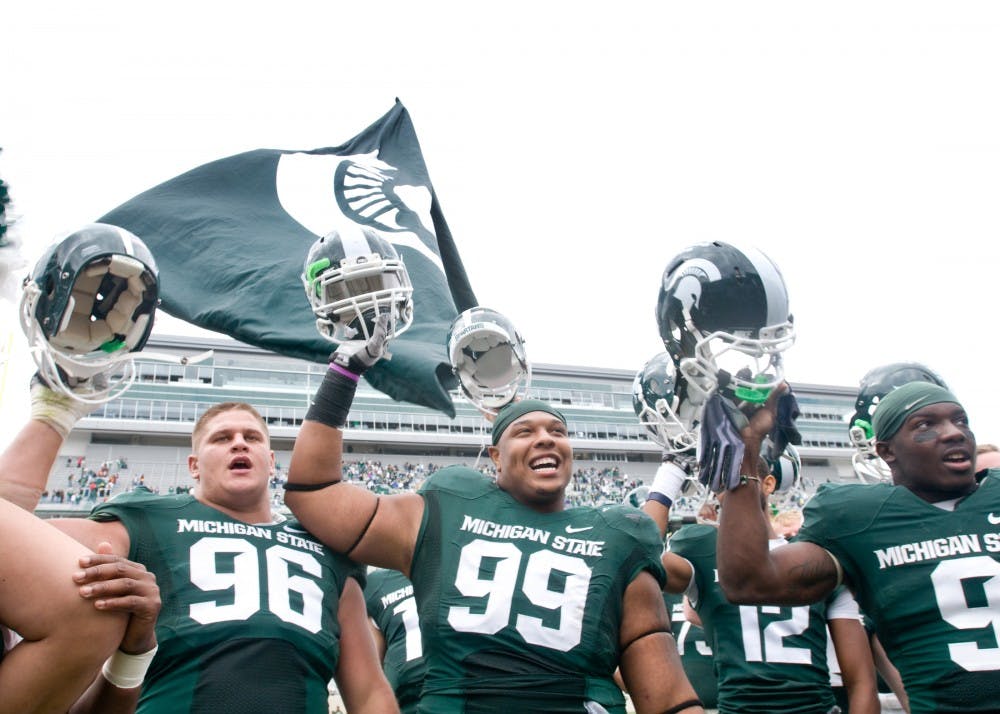 From left, senior nose tackle Kevin Pickelman, junior defensive tackle Jerel Worthy, and sophomore safety Isaiah Lewis sing the fight song to the student section after the game Saturday at Spartan Stadium. The Spartans defeated the Central Michigan Chippewas 45-7. Matt Radick/The State News