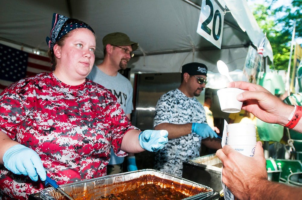 <p>Lansing residents Rachel Schineman, left, Kyle Hoffman, center, and Luis Segueda, right, serve guests May 30, 2014, at the MSU Culinary Services tent at the Annual BWL Chili Cook-Off at Adado Riverfront Park in Lansing. MSU Culinary services won third place is the meatless chili category. Corey Damocles/The State News</p>