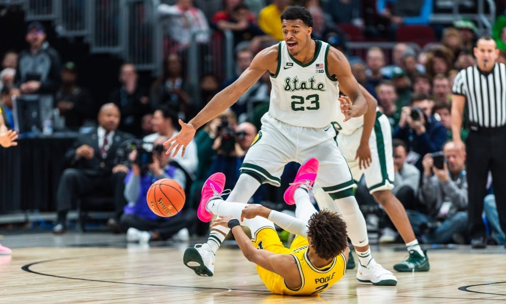 Sophomore forward Xavier Tillman forces Michigan's Jordan Poole into turning the ball over during the Big 10 Tournament Championship. The Spartans beat the Wolverines, 65-60, at the United Center on March 17, 2019.