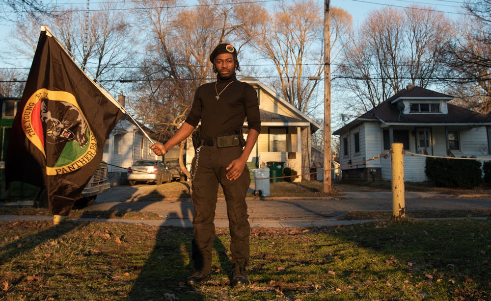 <p>James Henson holds a Black Panther Party flag on Bensch Street on March 11, 2021.</p>