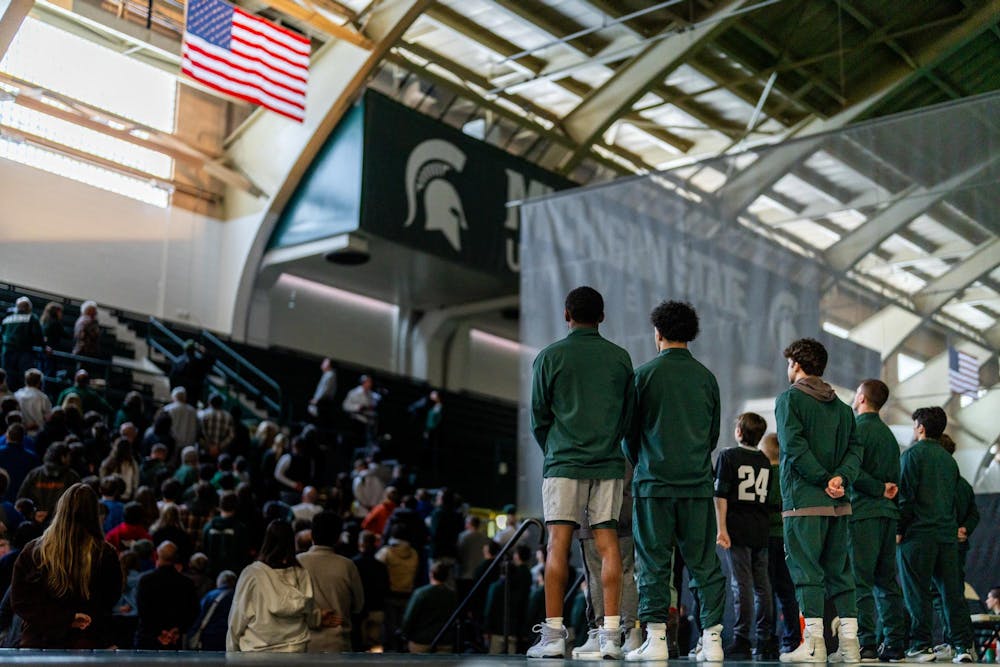 The MSU wrestling team looks to the American flag during the playing of the National Anthem in the Jenison Field House in East Lansing, MI on Feb. 8. 2026.