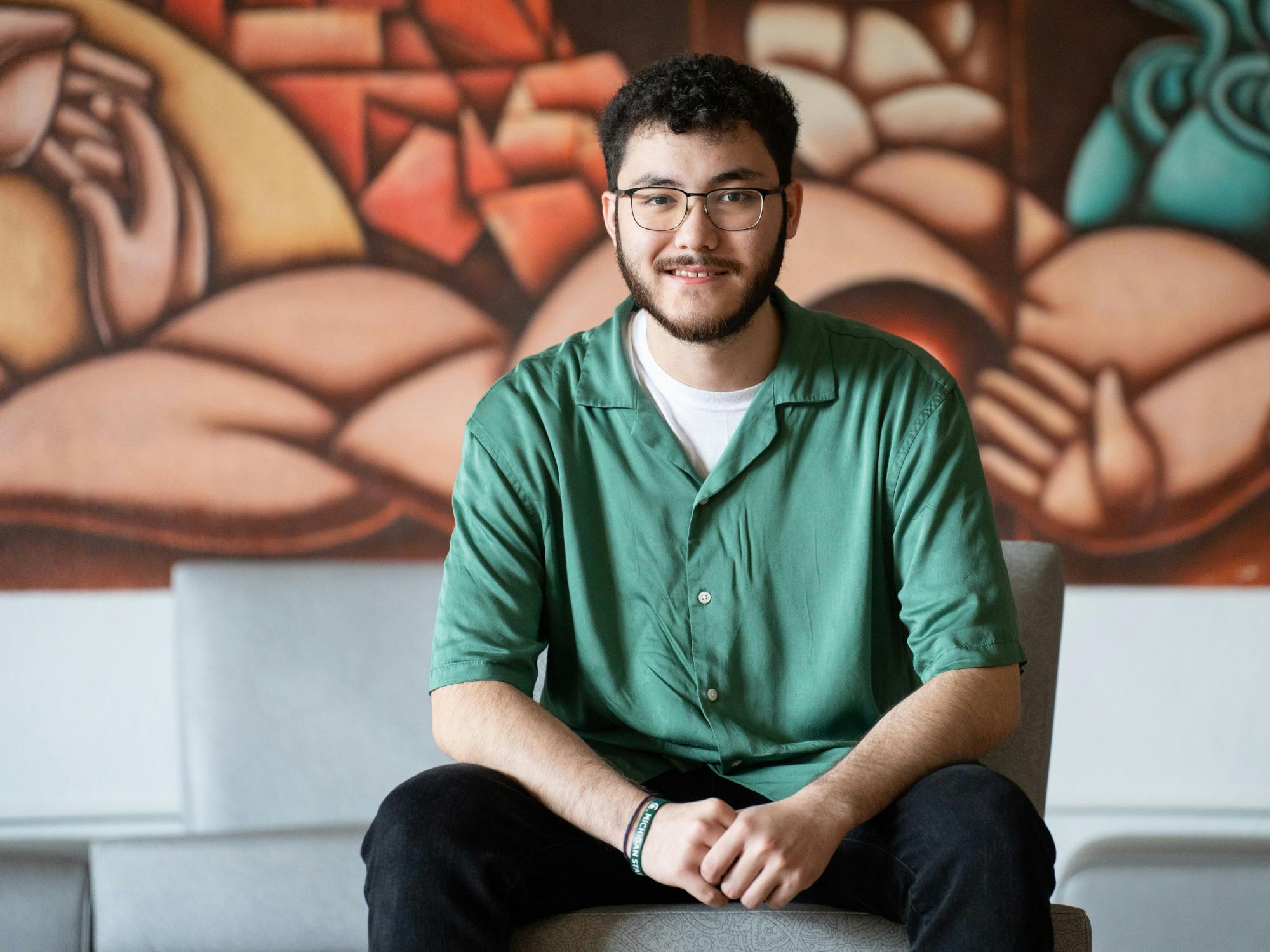 <p>APASO member Connor Le sits inside the Vincent Chin room in Holden Hall on July 14, 2022.</p>