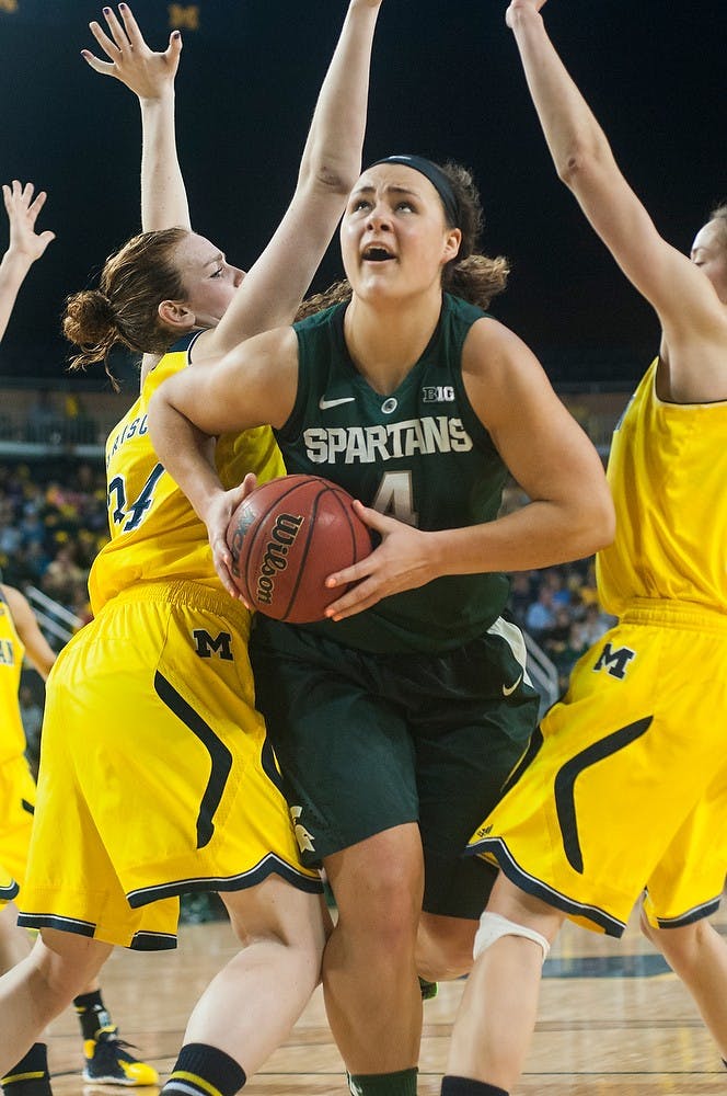 	<p>Junior center Jasmine Hines cuts between Michigan center/forward Val Driscoll, left, and guard Nicole Elmblad to go for a shot Jan. 12, 2014, at Crisler Center in Ann Arbor, Mich. The Spartans are tied with the Wolverines at the half, 28-28. Danyelle Morrow/The State News</p>