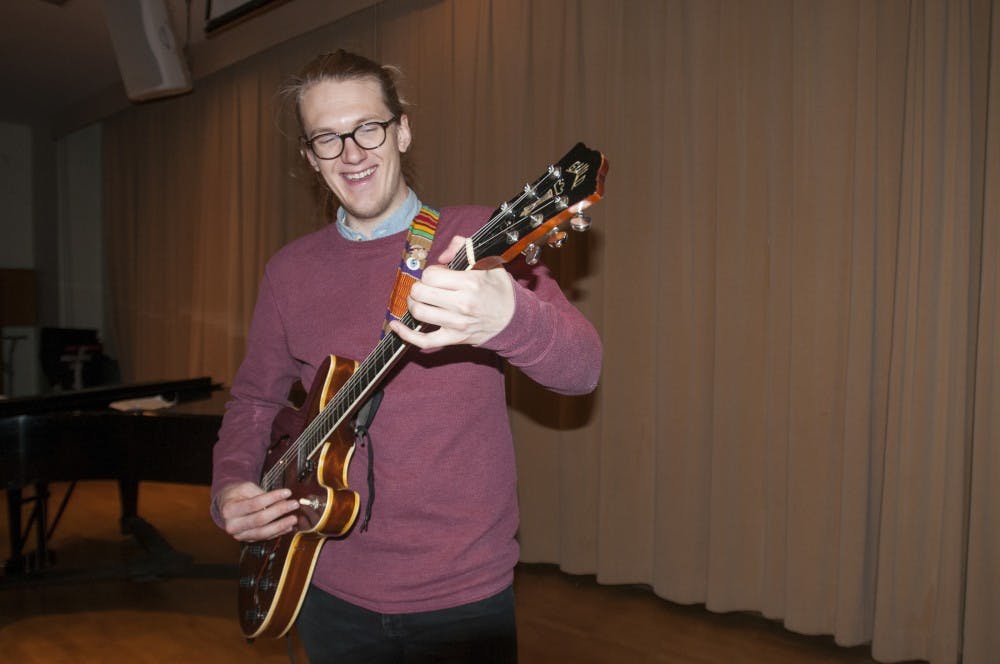 Jazz studies senior Eric Smith smiles after he played his guitar on Jan. 27, 2017 in Music Building. Smith played an original song and has been composing music since the age of 12. He explained why sharing his music is a passion for him, "This is how I've kind of always expressed myself; I've identified myself as someone who makes music... words are cool and music is cool but you can combine them. The other part is definitely the connecting thing."