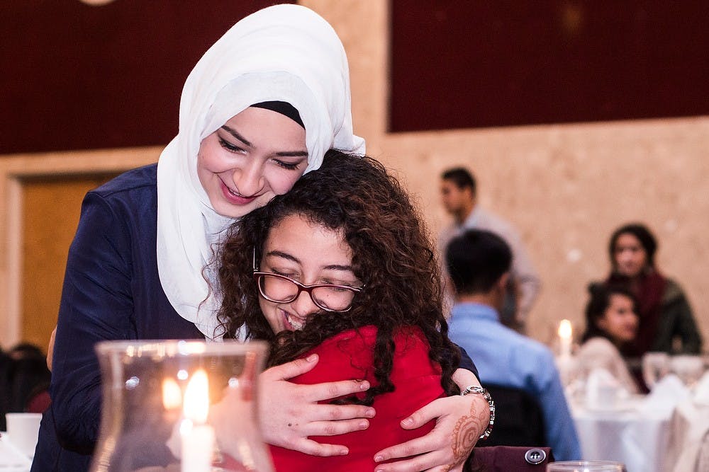 <p>Detroit resident and Wayne State University student Aya Elsherif, right, hugs friend and computer science sophomore Lama Aboubakr, left, Oct. 18, 2014, during the Muslim Student Association's celebration of Eid Al Adha at the MSU Union.  The association collaborated with the University of Michigan's association to celebrate Eid Al Adha, or Feast of the Sacrifice, which is one of the major religious holidays celebrated by Muslims annually. Erin Hampton/The State News</p>