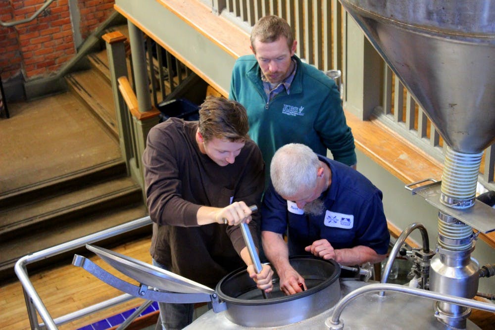 <p>People stir in Spartan barley to make the mash at New Holland Brewery in Holland, Mich.</p>