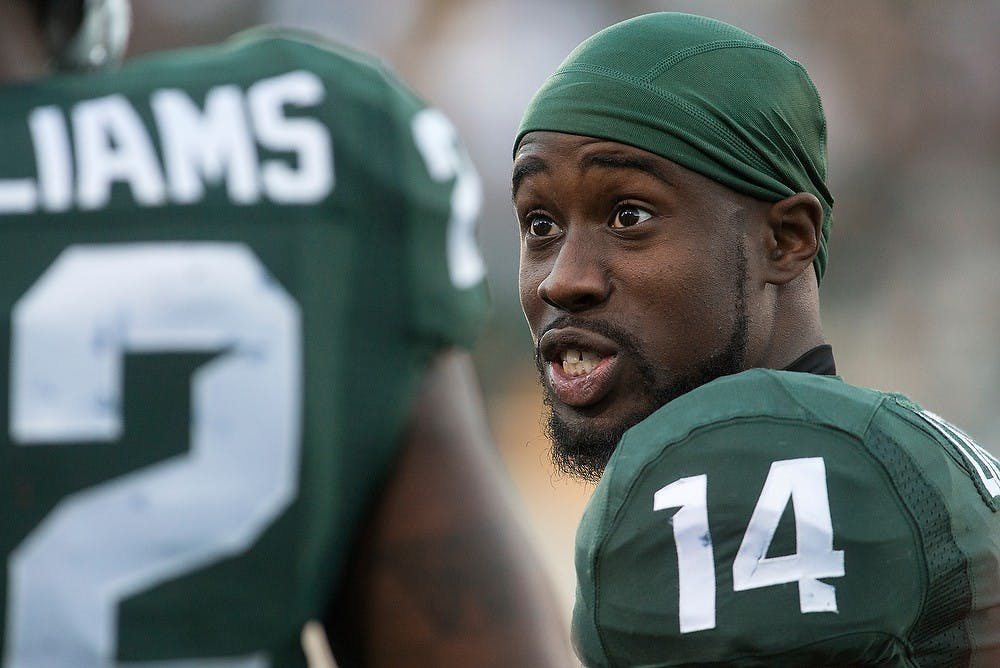 <p>Senior wide receiver Tony Lippett, 14, talks to sophomore running back Delton Williams during a timeout Oct. 25, 2014, during the game against Michigan at Spartan Stadium. The Spartans defeated the Wolverines, 35-11. Julia Nagy/The State News</p>