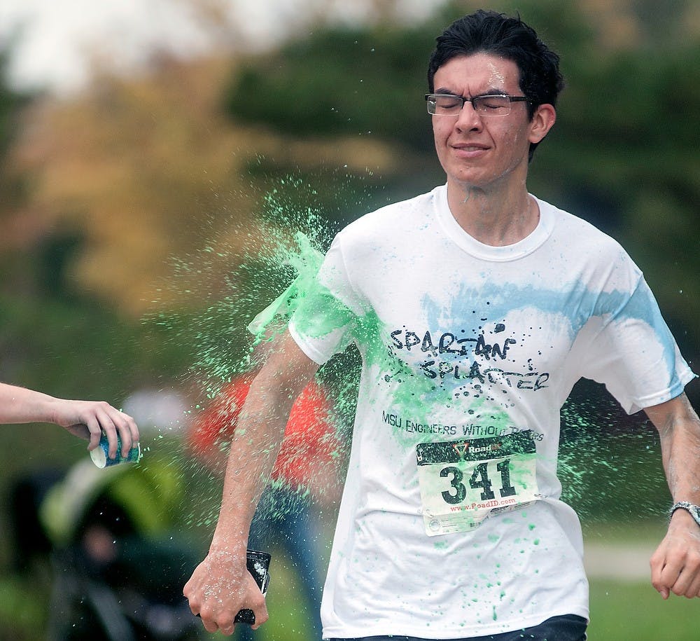 	<p>Mechanical engineering freshman Alex Wziontka finishes the race and gets splashed with paint Sunday, Oct. 14, 2012, during the Fall 2012 Spartan Splatter 5K race outside of Conrad Hall. The event hosted by Engineers Without Borders was able to gain near $5,500 to put toward the El Salvador sanitation project. Adam Toolin/The State News</p>