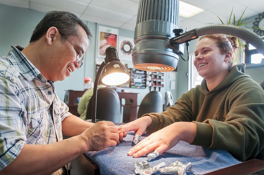 <p>Polished Nail Salon owner Charlie Nguyen works on a customer's nails Jan. 19, 2013. Nguyen was giving the customer a french manicure. Julia Nagy/The State News</p>