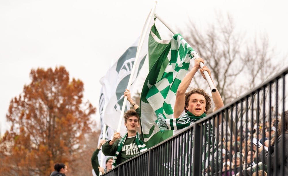 <p>Red Cedar Rowdies Porter Holden and Eli Flikkema run down the bleachers waving Spartan flags after MSU scored a goal during the NCAA soccer tournament game between MSU and WMU on Nov. 16, 2024. The Spartans defeated the Broncos, 3-1.</p>