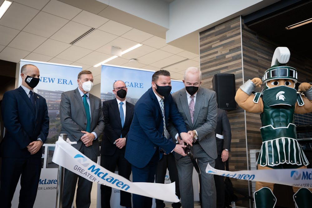 <p>President and CEO of McLaren Greater Lansing Kirk Ray and President and CEO of McLaren Health Care Phil Incarnati perform the ribbon cutting for the McLaren Health Care Center on Feb. 28, 2022.</p>