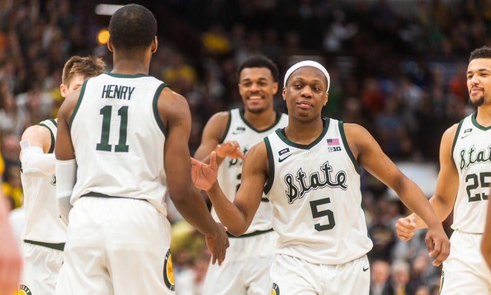 <p>Junior guard Cassius Winston (5) congratulates freshman forward Aaron Henry after Henry made game-sealing free throws. The Spartans beat the Wolverines, 65-60, at the United Center on March 17, 2019.</p>