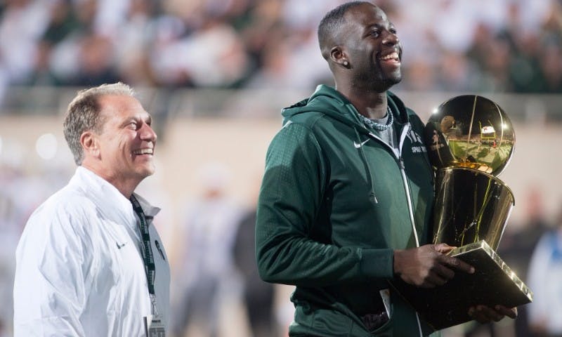 <p>MSU basketball Head Coach Tom Izzo and former Spartan and current Golden State Warrior forward Draymond Green look out at the crowd during the game against Oregon on Sept. 12, 2015 at Spartan Stadium. Green was recognized for his recent donation to the Spartan basketball program. (Alice Kole | The State News)</p>