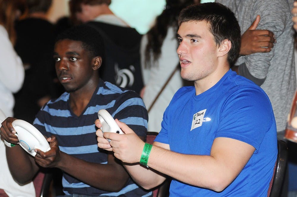 <p>Computer engineering sophomore James Meadows, left, and ecology and zoology freshman John Heslop participate in Spartans Will Game on Sept. 19, 2014, at the MSU Union. The University Activities Board (UAB) provided different gaming systems for students to enjoy. Aerika Williams/The State News </p>