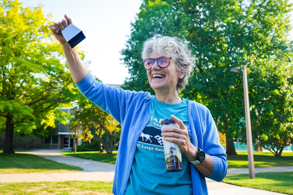 A participant cheers on runners with a cowbell during the Big Babies 5k Run at Conrad Hall on Sep. 15, 2024.