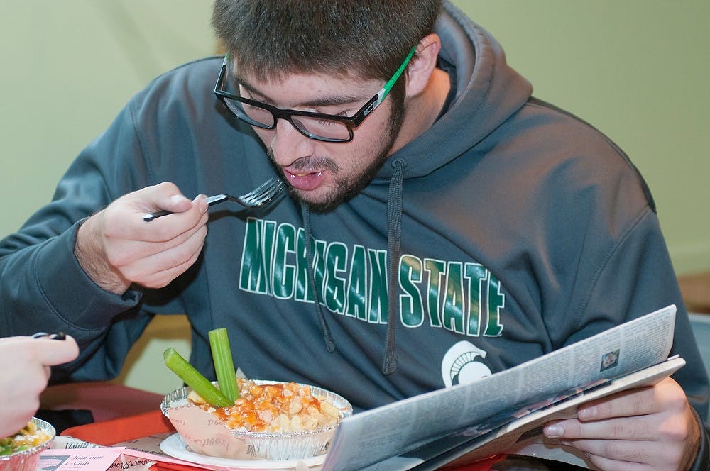 <p>Food science sophomore Bailey Weessies enjoys some macaroni and cheese on Sept. 15, 2014, at Sweet Lorraine's Fabulous Mac N' Cheez during their grand opening. Raymond Williams/The State News</p>