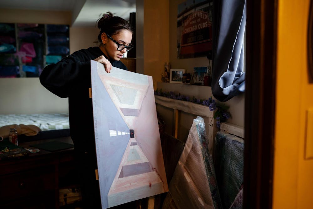 Fourth year Michigan State studio art senior Evan Yalowitz explains her piece titled “Aftermath Series: Lifeline” in her room on April 13, 2025. The painting is part of a larger series about school shootings. 