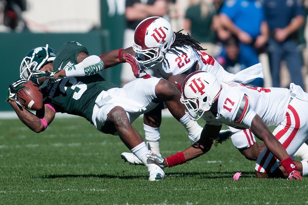 	<p>Indiana cornerback Michael Hunter, 17, and cornerback Kenny Mullen, 22, tackle sophomore wide receiver Macgarrett Kings Jr. on Oct. 12, 2013. The Spartans defeated the Hoosiers, 42-28. Julia Nagy/The State News </p>