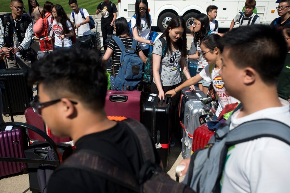 <p>International students sort out their luggage on Aug. 22, 2015, in front of Akers Hall during their move-in day. International move-in consisted of multiple Michigan Flyer buses dropping students off from the Detroit Metropolitan Wayne County Airport to Akers Hall. Students were then shuttled to their individual dorms. Julia Nagy/The State News</p>