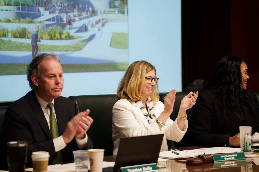 <p>MSU Interim President Woodruff and Trustee Kelly applauding the passing of a motion during a Board of Trustees meeting, held at the Hannah Administration Building on Feb. 10, 2023.</p>