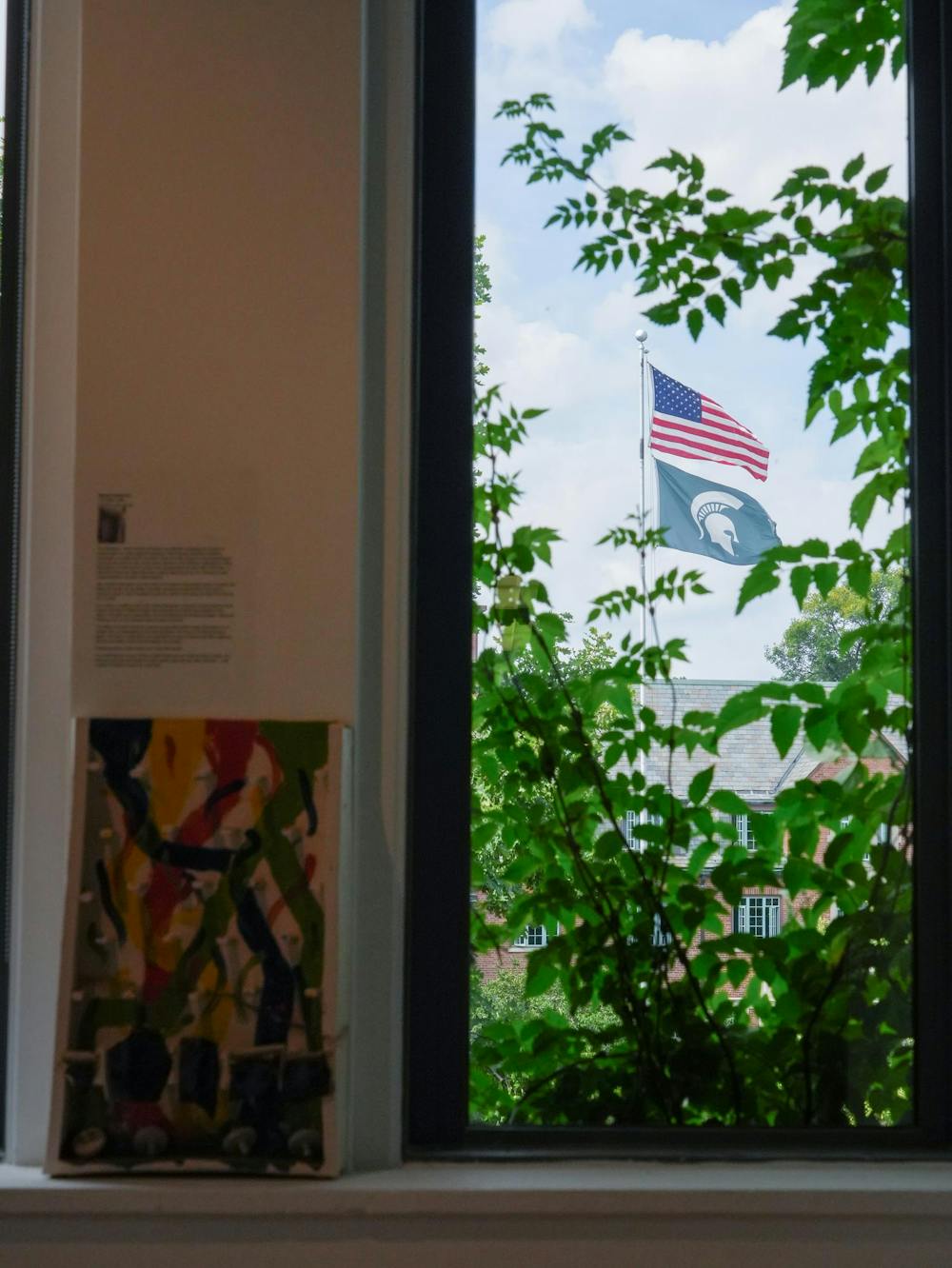 <p>An American flag and a Michigan State University flag wave outside the window of the Lasting Impressions exhibit in the MSU Union Art Gallery in East Lansing, Mich., on Tuesday, Sept. 8, 2026.</p>