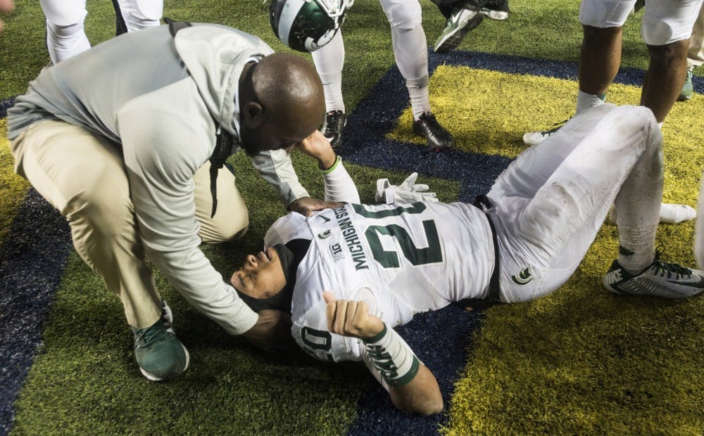 <p>Freshman defensive back Jalen Watts-Jackson lays on the ground after  running the game winning touchdown on Oct. 17, 2015, after the game  against Michigan at Michigan Stadium in Ann Arbor. The Spartans defeated  the Wolverines, 27-23.</p>