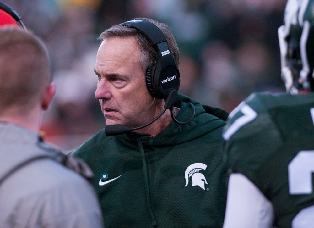 Head coach Mark Dantonio talks to his players on the field during the third quarter of the game against Penn State on Nov. 28, 2015 at Spartan Stadium. The Spartans defeated the Nittany Lions, 55-16.