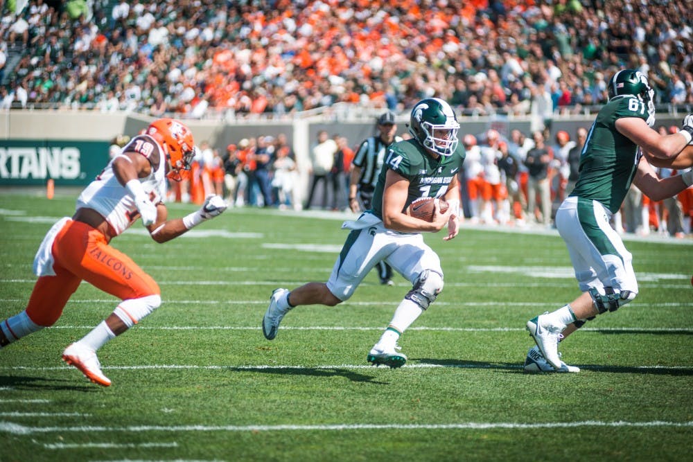 <p>Redshirt sophomore quarterback Brian Lewerke (14) runs the ball during the game against Bowling Green on Sep. 2, 2017, at Spartan Stadium. The Spartans defeated the Falcons, 35-10.</p>