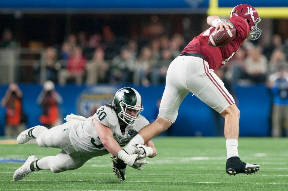 Junior linebacker Riley Bullough tries to tackle Alabama quarterback Jake Coker in the third quarter during the Goodyear Cotton Bowl Classic against Alabama on Dec. 31, 2015 at AT&T Stadium in Arlington, Texas. The Crimson Tide defeated the Spartans, 38-0.