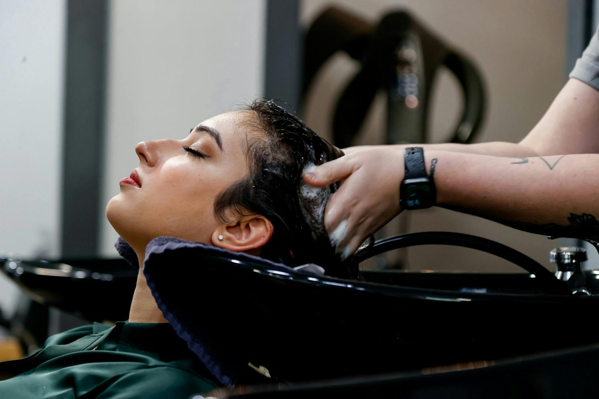 <p>Greeson massages shampoo into Rafique's hair as she prepares to blow it out and curl it.&nbsp;</p>