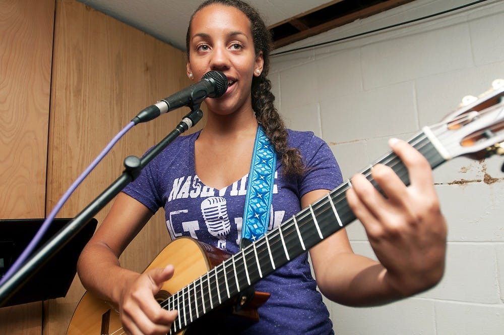 	<p>Taylor Taylor, 16, sings a song during a rehearsal on July 7, 2013, on Alpha Street in Lansing. She performs July 11, 2013 from 6:30 to 7:30 pm at the Common Ground Music Festival. Weston Brooks/The State News</p>
