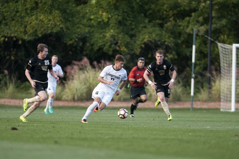 Sophomore forward Ryan Sierakowski (11) dribbles past Western Michigan University defenders on Oct. 5, 2016 at DeMartin Stadium at Old College Field. The Spartans defeated the Broncos 2-1 in overtime, with Sierakowski scoring both goals. 