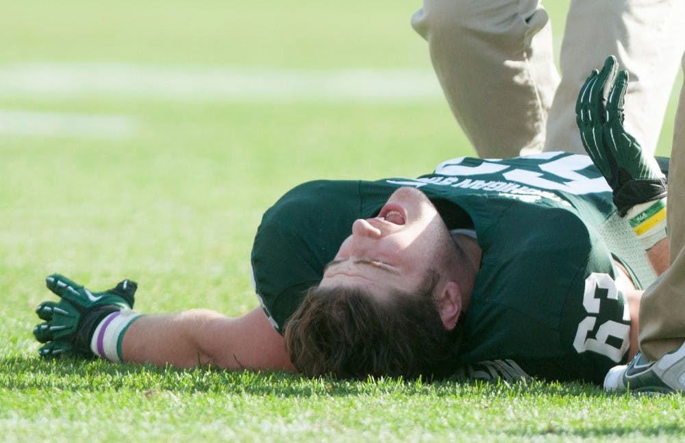 	<p>Sophomore center Travis Jackson stays on the ground after being injured during a game against Ohio State on Saturday at Spartan Stadium.</p>