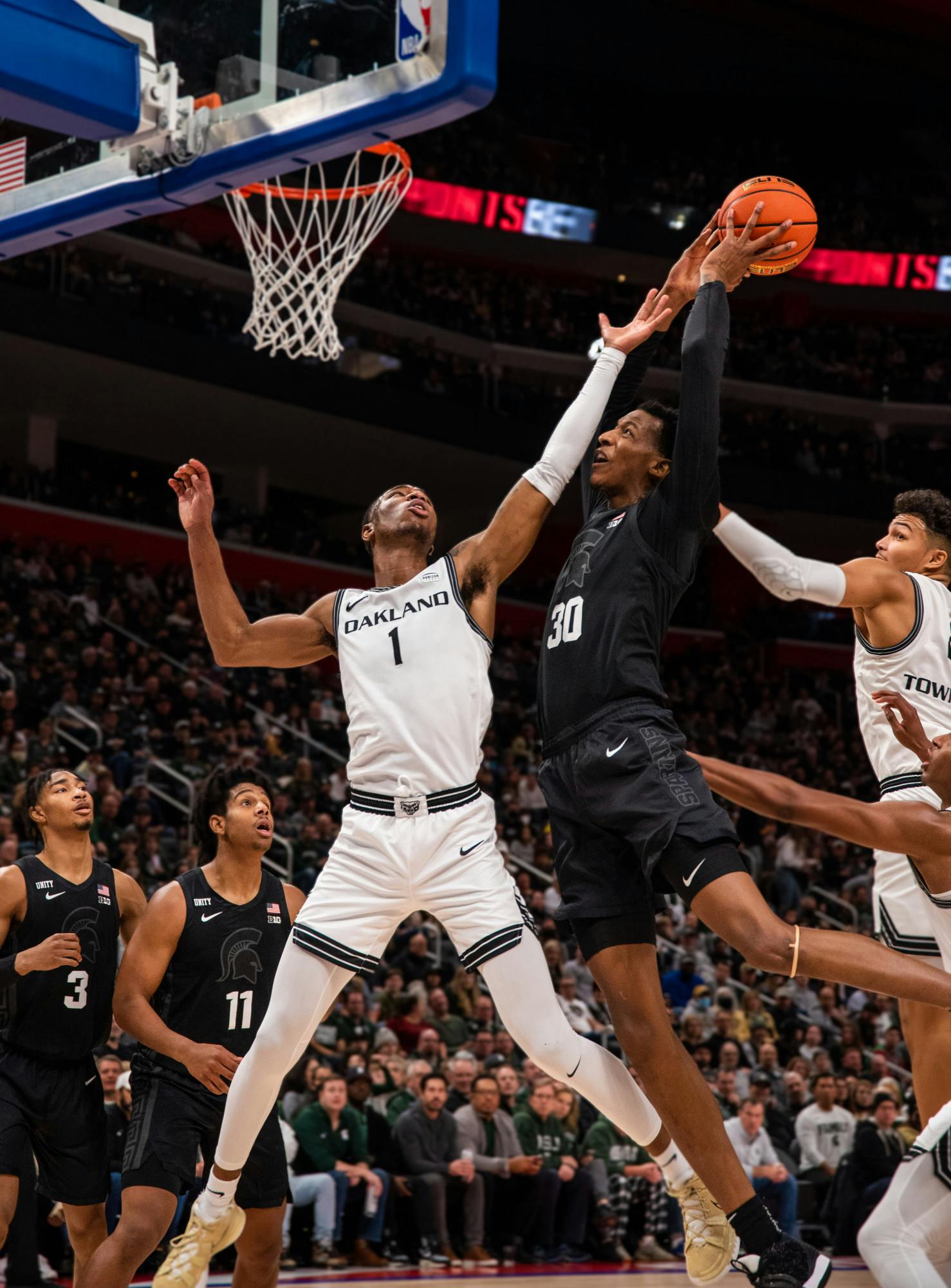 <p>MSU&#x27;s senior forward Marcus Bingham Jr. (30) shoots the ball over Oakland&#x27;s graduate forward Jamal Cain (1) in the Spartans&#x27; game against the Golden Grizzlies at Little Caesars Arena on Tuesday, Dec. 21, 2021. </p>