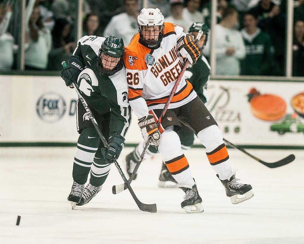 Freshman center Matt DeBlouw (left) races freshman right wing Mark Cooper of Bowling Green State to the puck Nov. 2, 2012, at Munn Ice Arena. The final score was 1-0, with Bowling Green coming out on top. Katie Stiefel/State News
