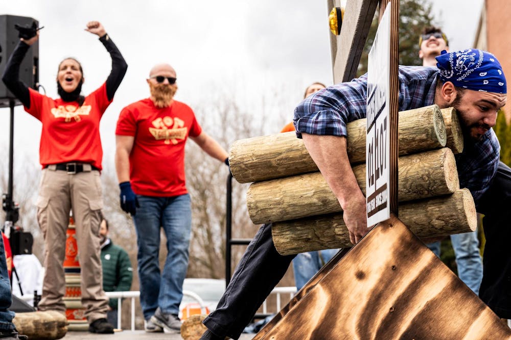 Participants compete in a penny limbo game during the annual Brrs, Beards & Brews: A Lumberjack Festival in Old Town Lansing, Mich., on Saturday, March 7, 2026.
