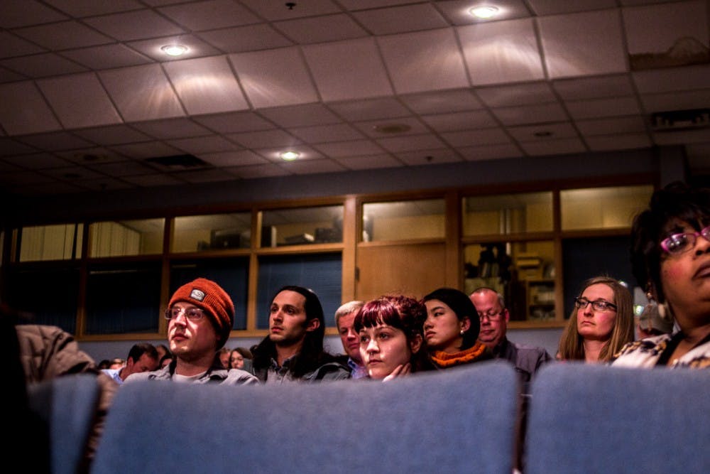 <p>People listen to Jarren Osmar speak to city council members on March 26, 2018 at the Lansing City Hall. Residents and activists gathered to voice their concern over medical marijuana dispensaries being denied operational rights in the city of Lansing.&nbsp;</p>