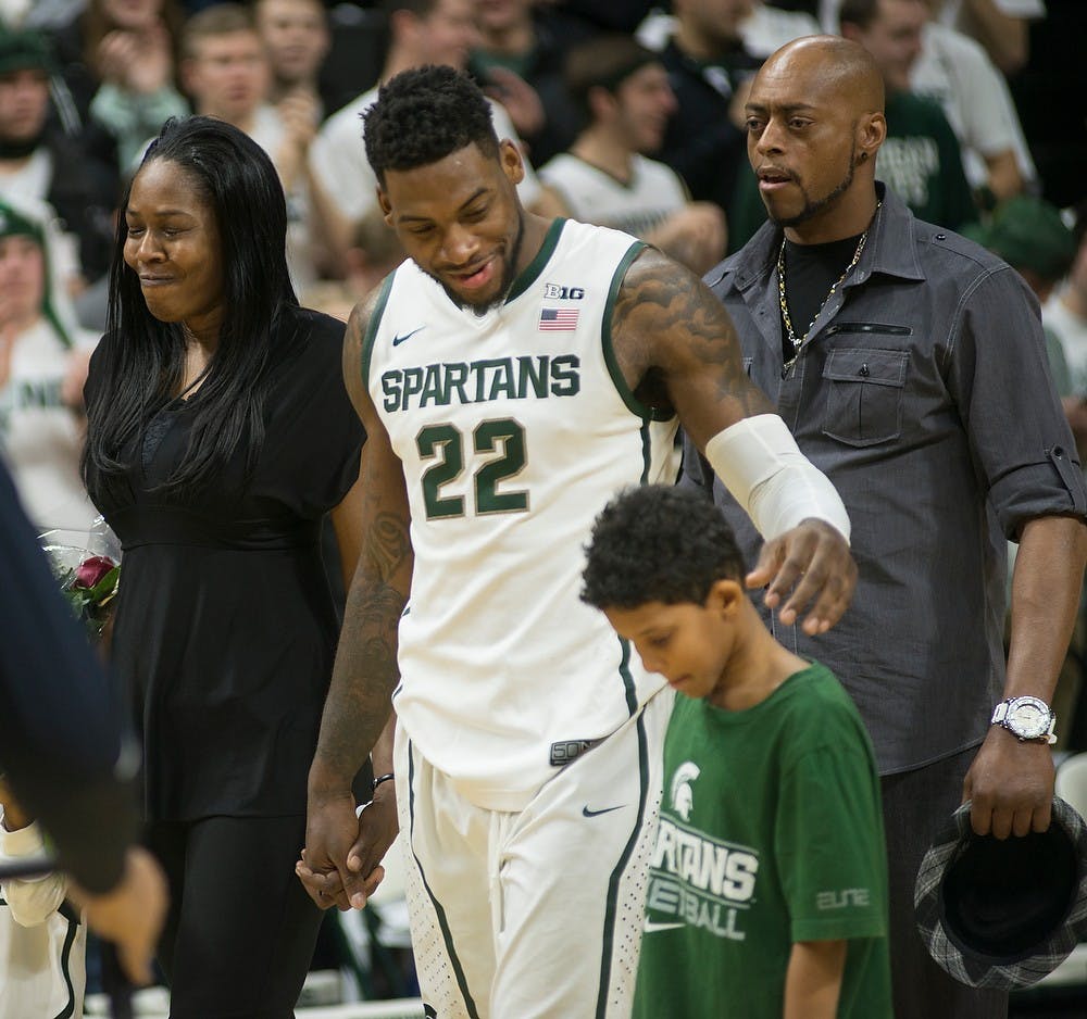 <p>Senior guard/forward Branden Dawson walks with his family Mar. 4, 2015, during the senior night celebration at the game against Purdue at Breslin Center. Every senior had his jersey framed and thanked everyone who supported them. Emily Nagle/The State News</p>