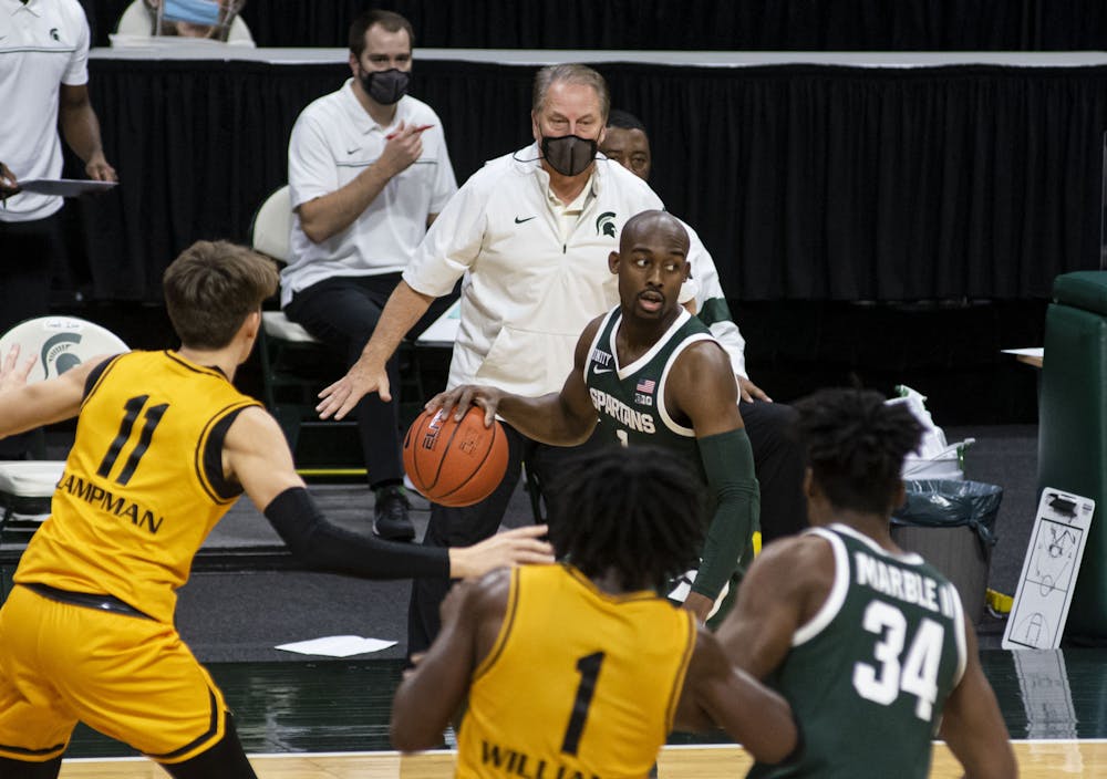 <p>Graduate student guard Joshua Langford (1) looks for an open teammate as coach Tom Izzo yells directions to the team in the second half. The Spartans came back after the first half to pull out a 109-91 win against Oakland University on Dec. 13, 2020.</p>