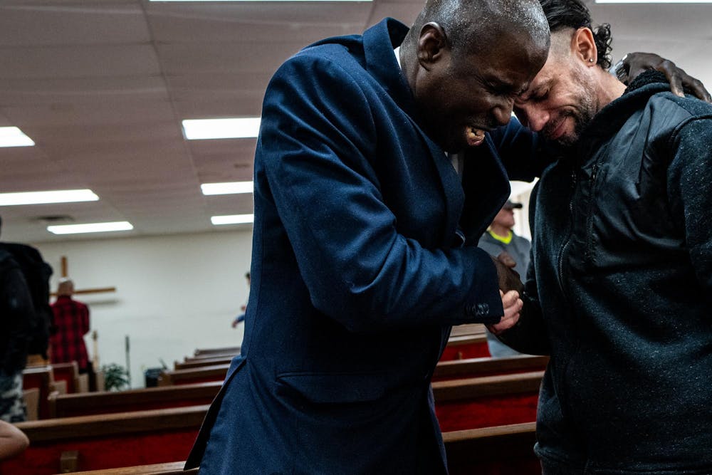 Pastor Michael Venyah prays for Rubin Roig, 42, of Puerto Rico, after a Sunday worship service at Soulwinners Fellowship Church in Lansing, Mich., on Sunday, April 12, 2026.